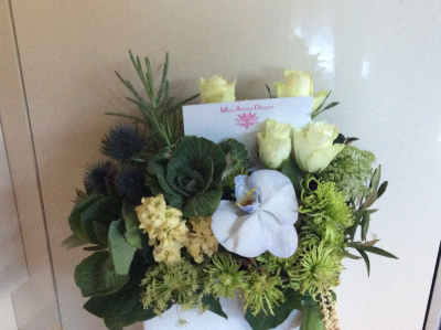 Horizontal elegance - Seasonal flowers beautifully arranged in a horizontal ceramic ,glass or tin with the inclusion of an orchid.colour theme upon request.